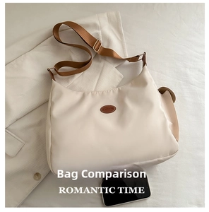 Detail view of beige nylon crossbody bag featuring a brown brand label and size comparison