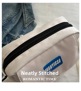 Close-up of sporty nylon crossbody bag with black zipper and blue FANYISSA logo patch