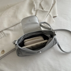 Silver metallic shoulder bag with magnetic flap closure and spacious interior storage