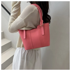 Detail of trendy pink crossbody bucket bag with elegant parallel stitching and long handles