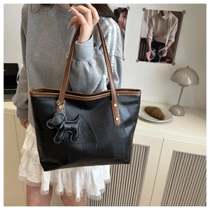 Détail du grand sac cabas noir texturé avec anses brunes et charm en forme de chien