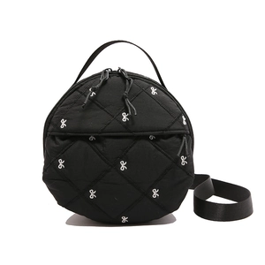 Chic black round quilted shoulder bag with white bow embroidery and top handle