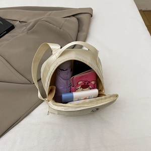 Cream nylon mini crossbody bag showing spacious interior with personal essentials