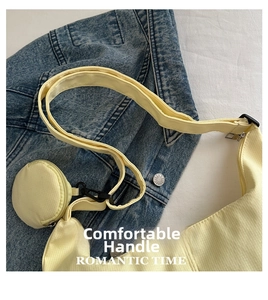 Detail of light yellow corduroy crescent bag with matching circular coin purse charm