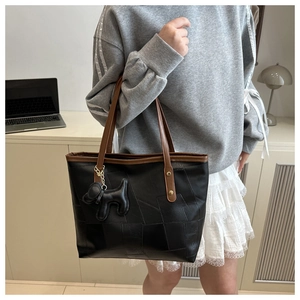 Détail du sac cabas noir en simili cuir patchwork avec un joli pendentif de chien