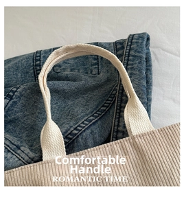 Detail of soft corduroy tote bag with durable reinforced woven handles in beige finish