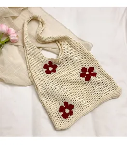 Vue détaillée du sac à bandoulière en maille ajourée avec broderies florales rouges