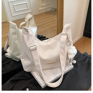 Détail du sac fourre-tout crème en cuir PU avec large sangle et breloque nuage