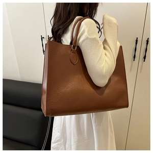 Brown crocodile embossed tote bag with large capacity and sturdy top handles on a model