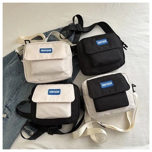 Detail view of nylon square crossbody bags in black and white colors with adjustable straps