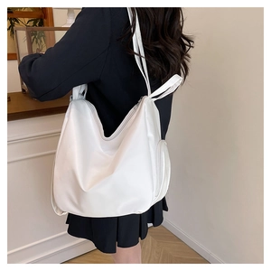 Detailed side view of white pleated leather tote bag showing large capacity and zipper pocket