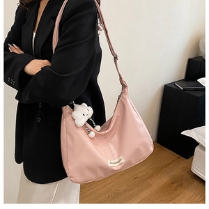 Sac bandoulière rose en nylon imperméable avec un pendentif peluche nuage blanc