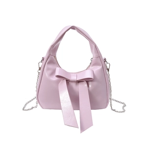 Pink bow handbag with faux leather texture and a detachable metal chain strap