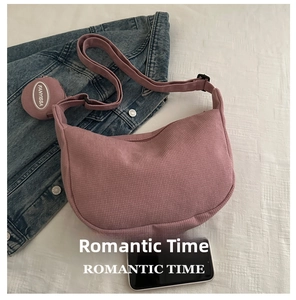 Detail of waffle-textured pink crescent bag with adjustable strap and small coin purse
