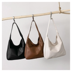 Hanging display of vintage tote bags in black, brown, and cream matte leather finish