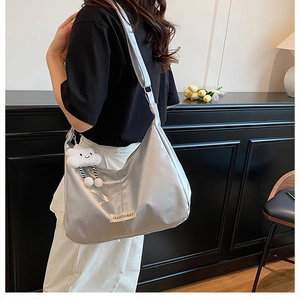 Sac à bandoulière argenté métallisé avec étiquette mode et breloque nuage sur modèle