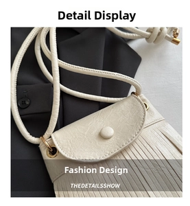 Detail of cream white leather mini bag with elegant long fringe and flap closure design