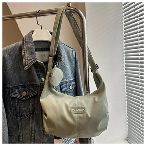 Détail du sac bandoulière croissant en velours côtelé vert clair avec petit porte-monnaie