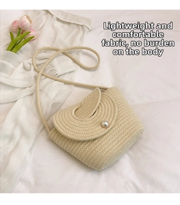 Detail of woven straw crossbody bag featuring a single pearl closure and thin cord strap