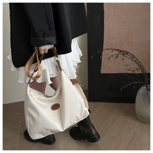Détail du grand sac cabas en oxford blanc cassé avec patch en cuir et large bandoulière