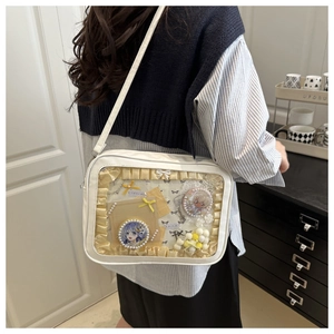 Detailed close-up of a white ita bag with transparent window and anime badges