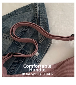 Detailed macro of pink corduroy shoulder strap with metal zipper and buckle accents