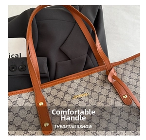 Nahaufnahme der geometrischen Monogramm-Canvas-Tasche mit braunen Ledergriffen und Goldlogo