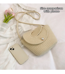 Detail of beige woven mini crossbody bag with pearl buckle and tulip floral background