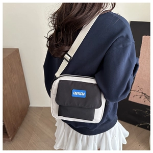 Detail of a square canvas crossbody bag with FANYISSA blue label and adjustable strap