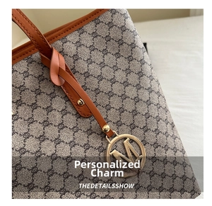 Detailaufnahme der Vintage-Monogramm-Tasche mit braunem Lederbesatz und goldenem M-Anhänger