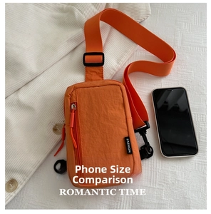 Close-up of orange nylon crossbody bag with fashion label and adjustable strap