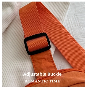Close-up of adjustable orange nylon shoulder strap with durable black plastic buckle