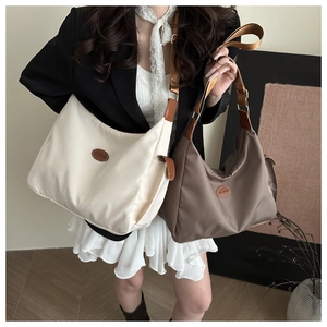 Détail de grands sacs fourre-tout Oxford en crème et marron avec patchs logo mode