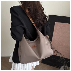 Détail du tissu Oxford imperméable et de l'étiquette en cuir marron sur le sac cabas