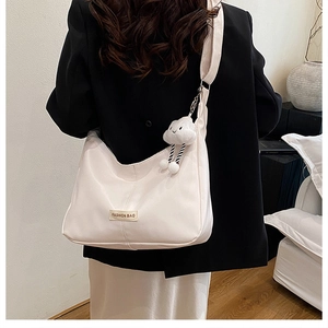 Vue arrière d'un sac bandoulière crème avec breloque nuage et bandoulière réglable