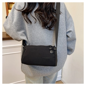 Dettaglio della borsa a tracolla in nylon nero con cinturino in tessuto sul modello
