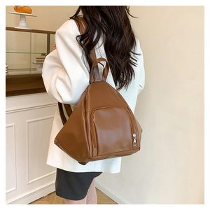 Detailed close-up of brown PU leather backpack with a sleek triangular slouchy design