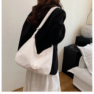 Vue détaillée du sac hobo blanc cassé avec étiquette de mode et bandoulière réglable