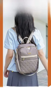 Detailed view of the diamond-quilted pattern and gold rivets on this gray-purple backpack