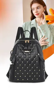 Detail view of black PU leather backpack with gold rivets and cute bear charm