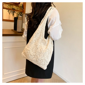Detail showing white crochet tote bag with pearl embellishments in soft indoor lighting