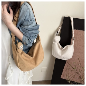 Detail of corduroy half-moon shoulder bag with matching round coin purse in tan and beige