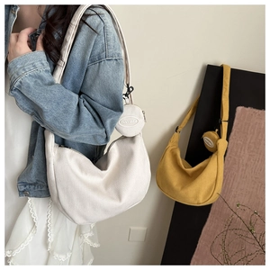 Detail of corduroy crossbody bag with matching detachable round coin purse in cream and yellow