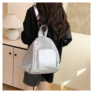 Macro shot of silver metallic pleated backpack featuring a unique triangular 3D design