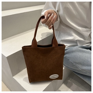 Detail of brown corduroy tote bag showing striped texture and FANYISSA brand label