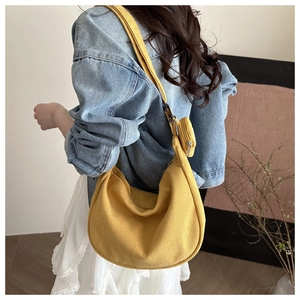 Detail of mustard yellow corduroy crescent bag with a small round detachable pouch