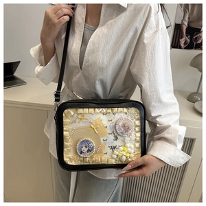 Detail of black ita bag with clear window, yellow lace trim and adjustable shoulder strap