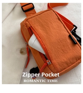 Detail of a bright orange waterproof nylon mini crossbody bag with a front zipper pocket