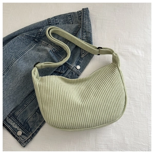 Detail of light green corduroy hobo bag showing soft texture and adjustable strap buckle
