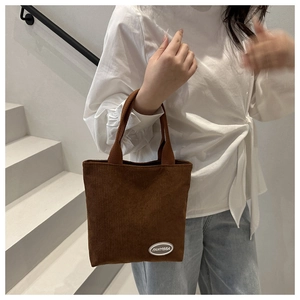 Close-up of brown corduroy tote bag featuring ribbed texture and FANYISSA brand label